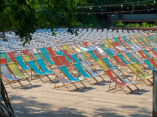 Many colorful deck chairs in summer park. Stylish chairs standing in an open-air cinema on the...