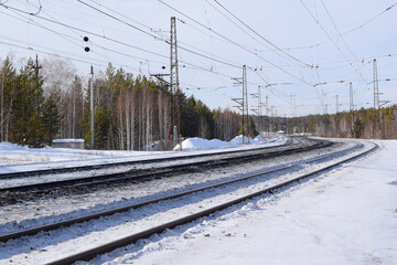 Railway winding tracks go into the distance beyond the horizon, winter landscape.