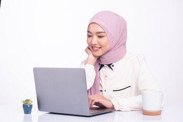 Young muslim woman working on laptop in office. Portrait.