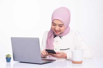 Young pretty modern muslim woman in hijab working on laptop in office. Entrepreneur, e-Commerce concept