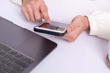 Close up, Woman with a finger on the screen using a mobile phone in the office.