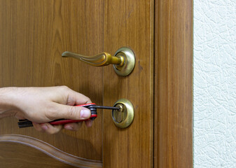 A burglar opens the door of an office or home. The thief picks up a lockpick for the door. Office or home security. Break-in.