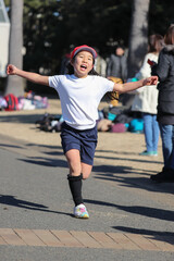 小学校のマラソン大会で走ってゴールする女の子