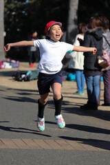 小学校のマラソン大会で走ってゴールする女の子