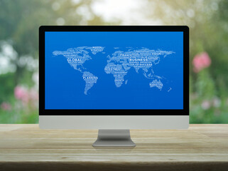 Global business words world map on desktop modern computer monitor screen on wooden table over blur flower and tree in park, Global business online concept, Elements of this image furnished by NASA