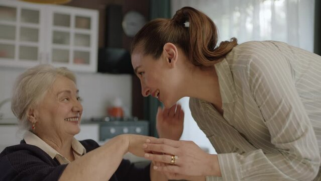 Woman kissing her mother's hands, celebrating Eid or Mother's Day.The woman kissing her old mother's hands during the feast (Ramadan or Şeker Bayram). People who follow Muslim traditions.