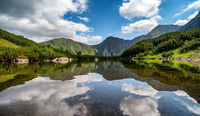 Naklejka na ściany i meble Reflection of hill and on water surface of mountain lake in Western tatras in Slovakia
