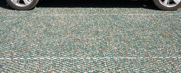 New modern car park with gravel base and plastic mesh. Selective focus.