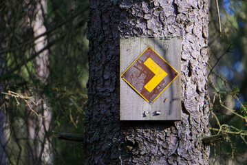 A yellow and brown hiking arrow sign