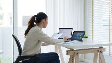 Back rear view of young asian woman, freelance data scientist work remotely at home coding programing on Big data mining, AI data engineering, IT Technician Works on Artificial Intelligence Project.