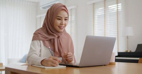 Asia arab people young woman wear hijab headscarf plan study MBA college class note idea data in sale report remote work at home on laptop. Happy advisor lifestyle smile cowork smart workforce job.