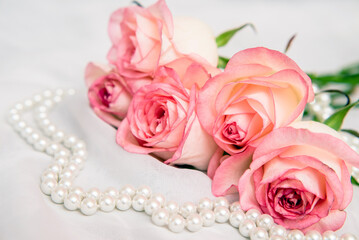 The branch of pink rose on white fabric background
