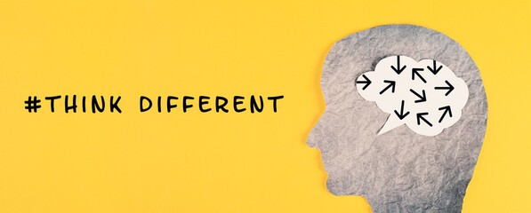 Think different stands on the yellow background, head with brain, being a nonconformist, standing...