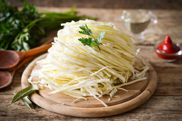 Shredded white cabbage on a wooden board.