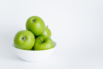 bowl with green and ripe apples on white.