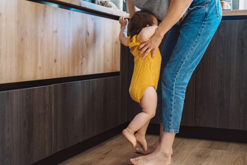 The mother raises the baby, who cries that she wants in the mother's arms. Pick up standing baby....