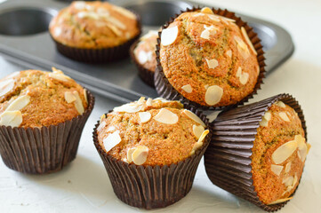 Homemade muffins. Muffins in a baking dish. Muffins garnished with almonds. Muffins on a white background.