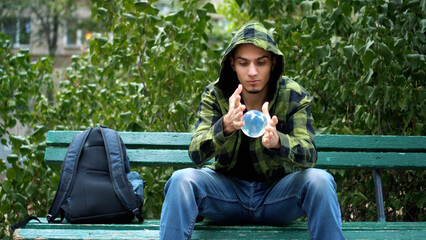 Artist shows trick with transparent sphere. Guy is engaged in juggling.