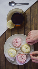 Table decoration for delicious dessert. Marshmallow on white plate. Holiday gift concept. Food harmful to diabetics, soft focus. Mug of tea and spoon on napkin.