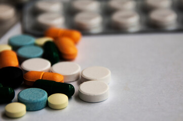 Assorted pharmaceutical medicine pills, tablets and capsules with blurred background over white background. Concept of healthcare and medicine. Copy space.