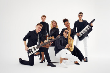Portrait of diverse group of young people musical band playing with instruments - isolated on white...