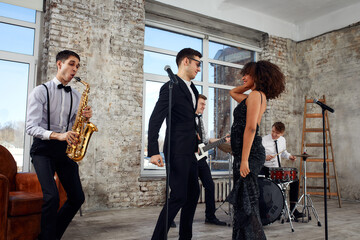 Repetition of multi ethnic jazz band in loft. Bass guitar player, electric guitar player,...