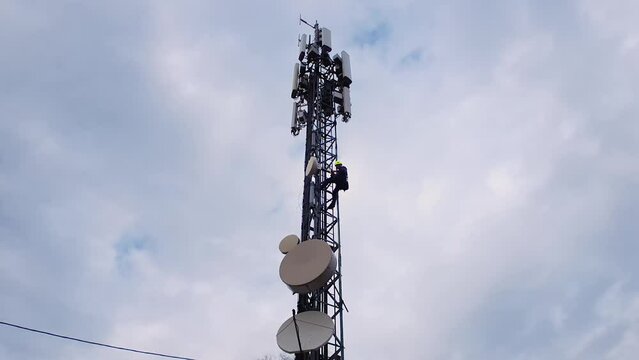 Engineer technician servicing antenna on telecom tower after Internet failure. Timelapse, zoom in shoot.