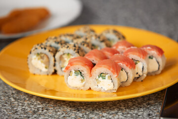 Traditional Japanese food, Asian cuisine with copy space. Yellow plate with rolls on table. Top view, close-up.