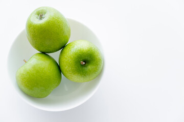 top view of fresh apples in bowl on white.