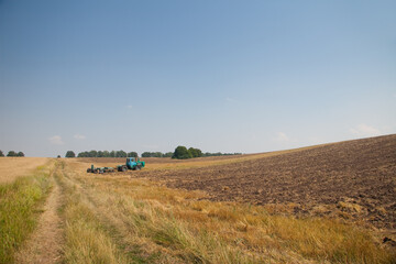 Modern tractor in the field with complex for the plowing. The concept of work in a fields and...