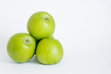 green and organic apples on white.