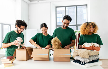 charity, donation and volunteering concept - international group of happy smiling volunteers...