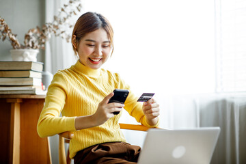 Online payment, Asian girl, using smartphone and laptop holding credit card for online shopping