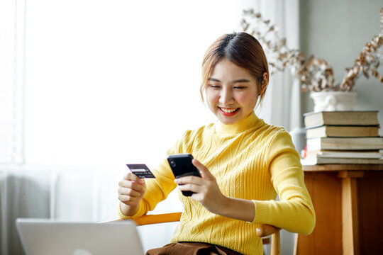 Online payment, Asian girl, using smartphone and laptop holding credit card for online shopping