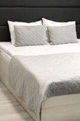 Comfortable hotel bed with soft pillow and bedding