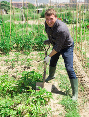 Man professional horticulturist with garden shovel working at land in garden