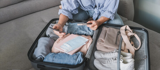 Travel. Online travel plans with Covid passport and Covid test. Traveling after quarantine, lockdown, covid 19. Staycation.local travel new normal.Girl packs baggage in suitcase and travel documents