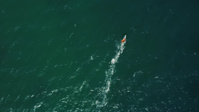 Aerial drone view of windsurfer enjoying on blue sea ocean waves.