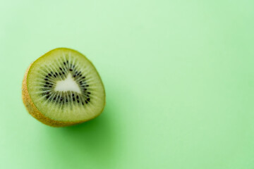 top view of kiwi fruit half on green. - obrazy, fototapety, plakaty