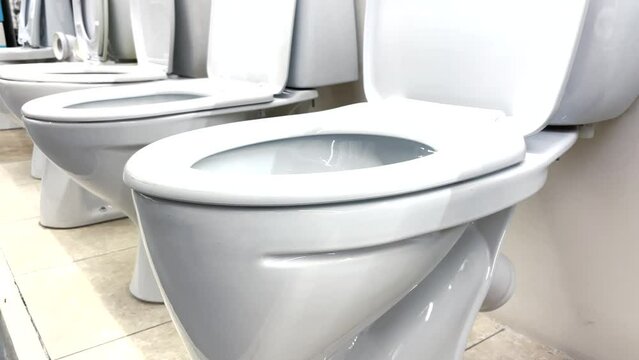 toilet in plumbing store. bathroom equipment a many toilets stand on the floor in the store. repair replacement of the toilet in lifestyle the bathroom choice in the plumbing store