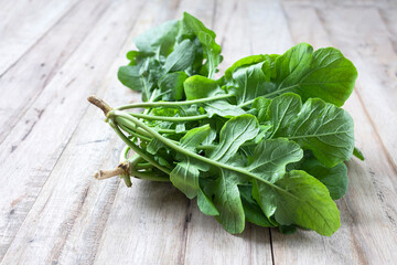 Fresh Arugula leaf on wood background.