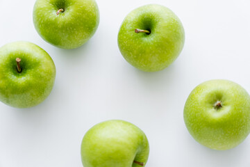top view of green and ripe apples on white.