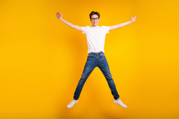 Fototapeta na wymiar Full length photo of young guy good mood jump up wear casual clothes isolated over yellow color background