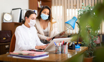 Successful business woman with secretary during daily work at modern office during coronavirus pandemic