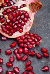 Pomegranate broken open with pips on a grunge surface with copy space