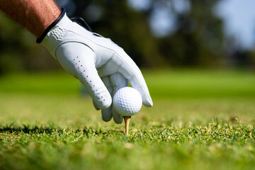 Golfer hitting golf shot with club on course. Hand with golf glove. © Volodymyr