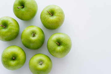 top view of whole green apples on white with copy space.