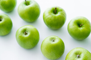 high angle view of delicious green apples on white. - obrazy, fototapety, plakaty