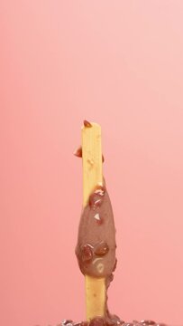 red bean popsicle melting on pink timelapse at vertical composition