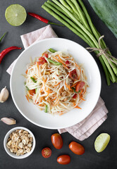 Traditional Thai papaya salad with tomatoes, peanuts, green beans, chili peppers. Ingredients for making papaya salad. Thai food top view.